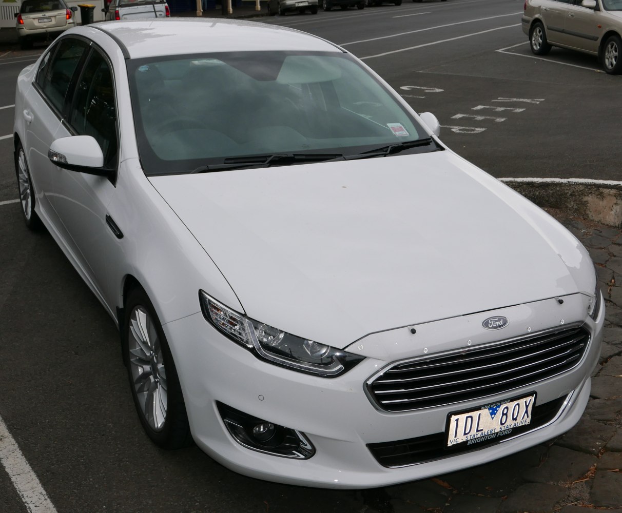 White sedan front with sleek grille and LED headlights