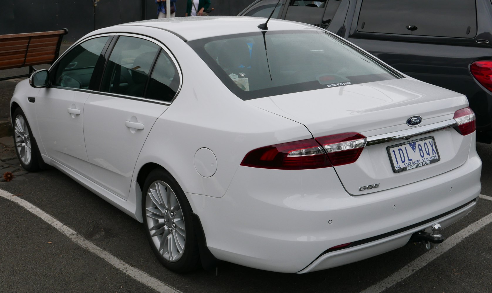 White sedan with alloy wheels and rear tow hitch