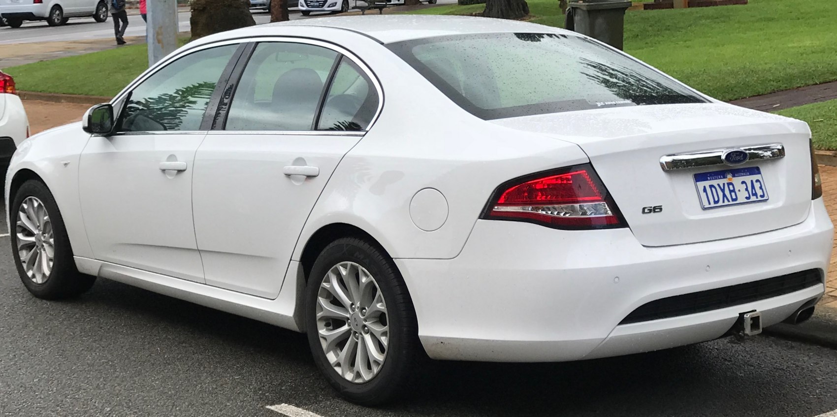 White sedan rear side view with distinct taillights and alloy wheels