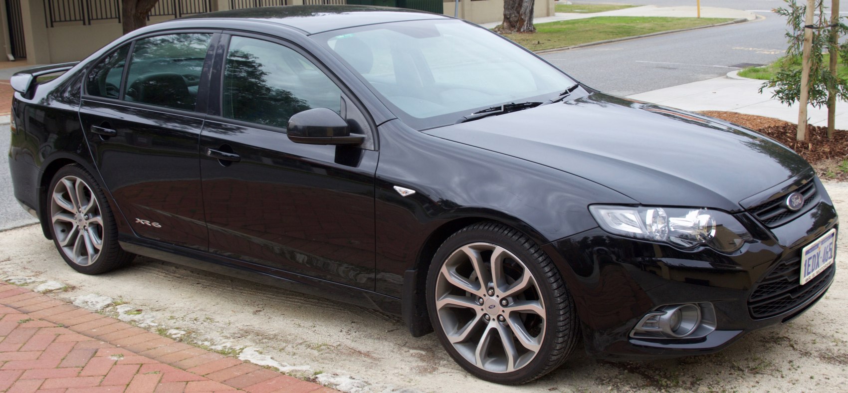 Front side view of black sedan with alloy wheels and modern headlights