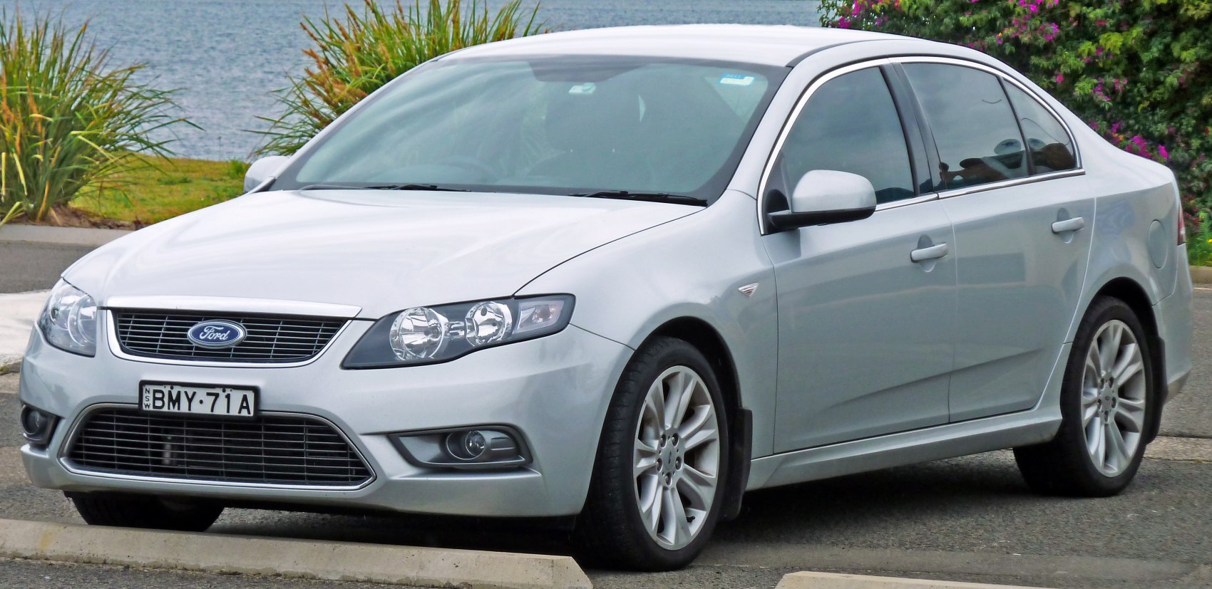 Silver sedan with front grille, headlights, and alloy wheels