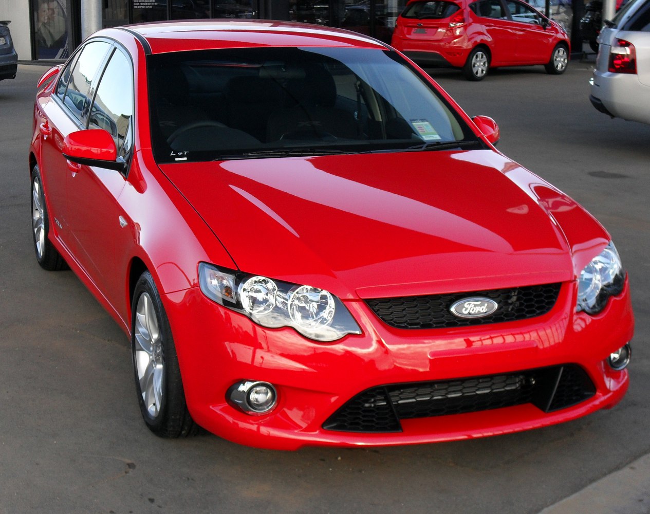 Front view of a red sedan with distinctive headlights and grille
