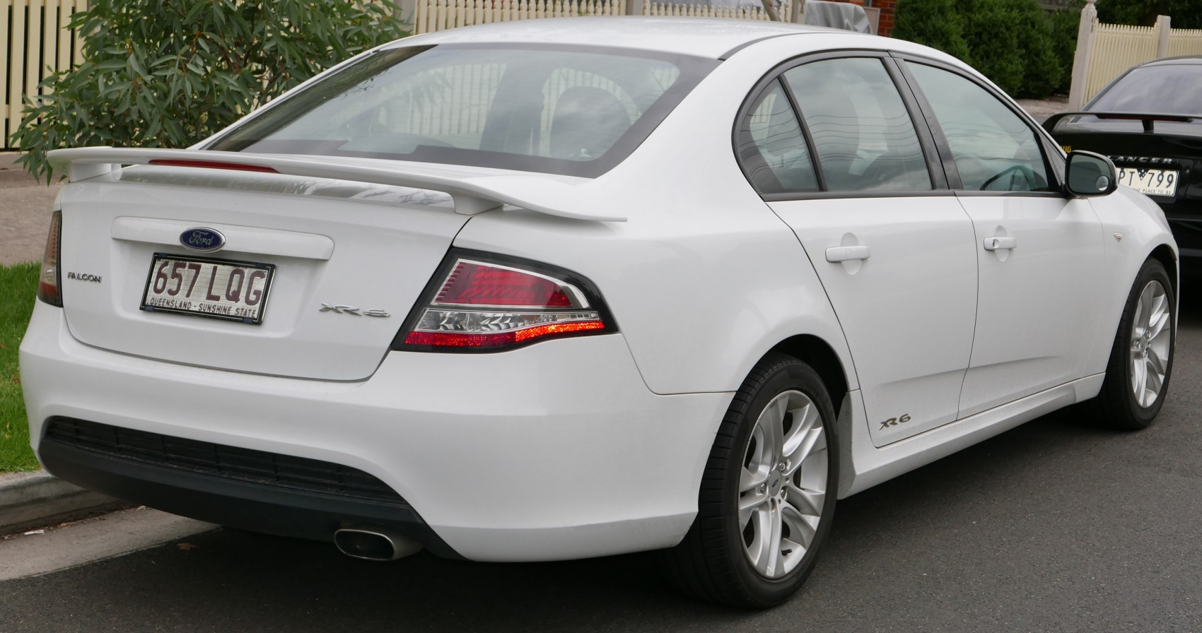 Rear and side view of a sedan with spoiler and alloy wheels