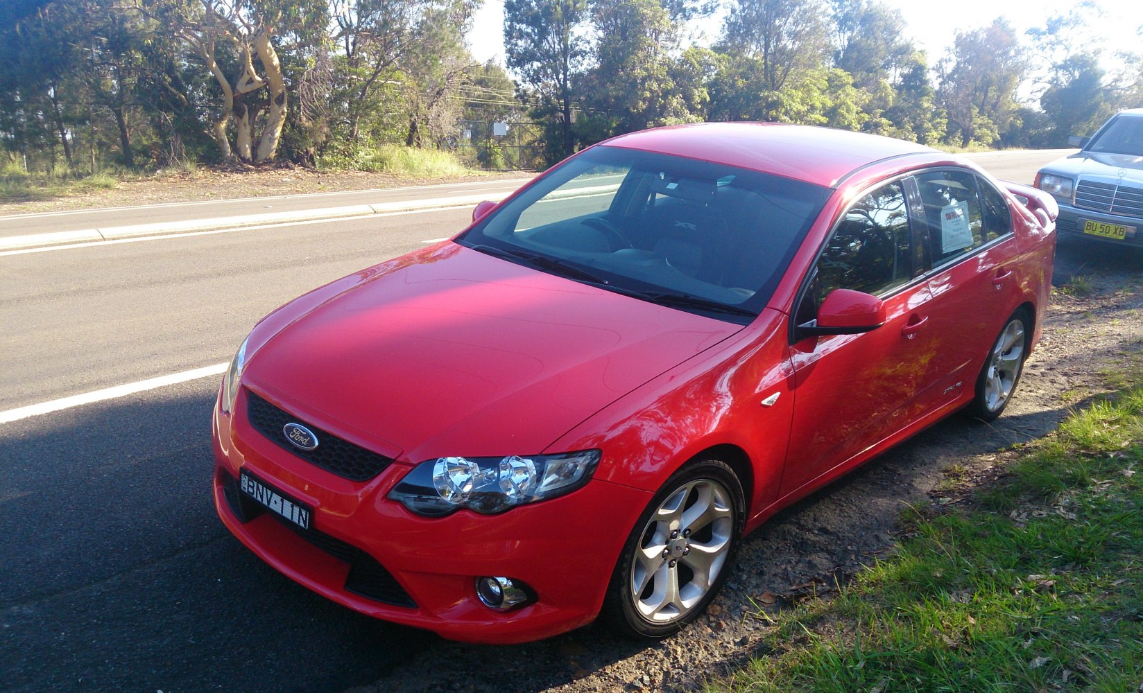 Red sedan with sporty alloy wheels and front fog lights