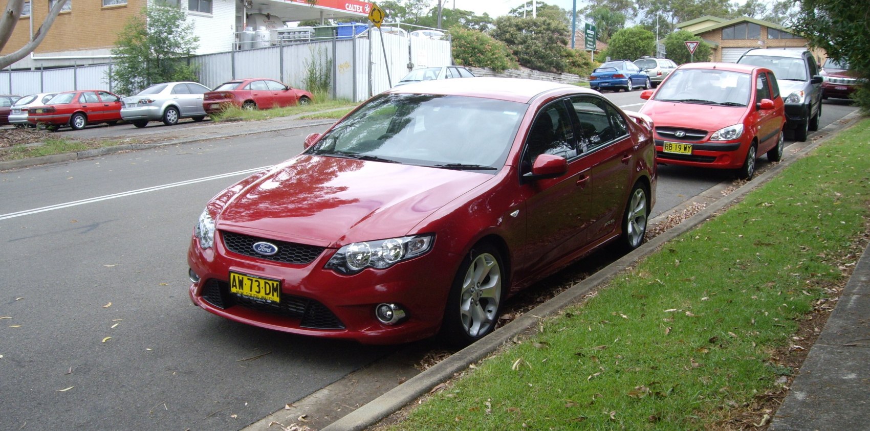 Front view of red sedan with alloy wheels and fog lights
