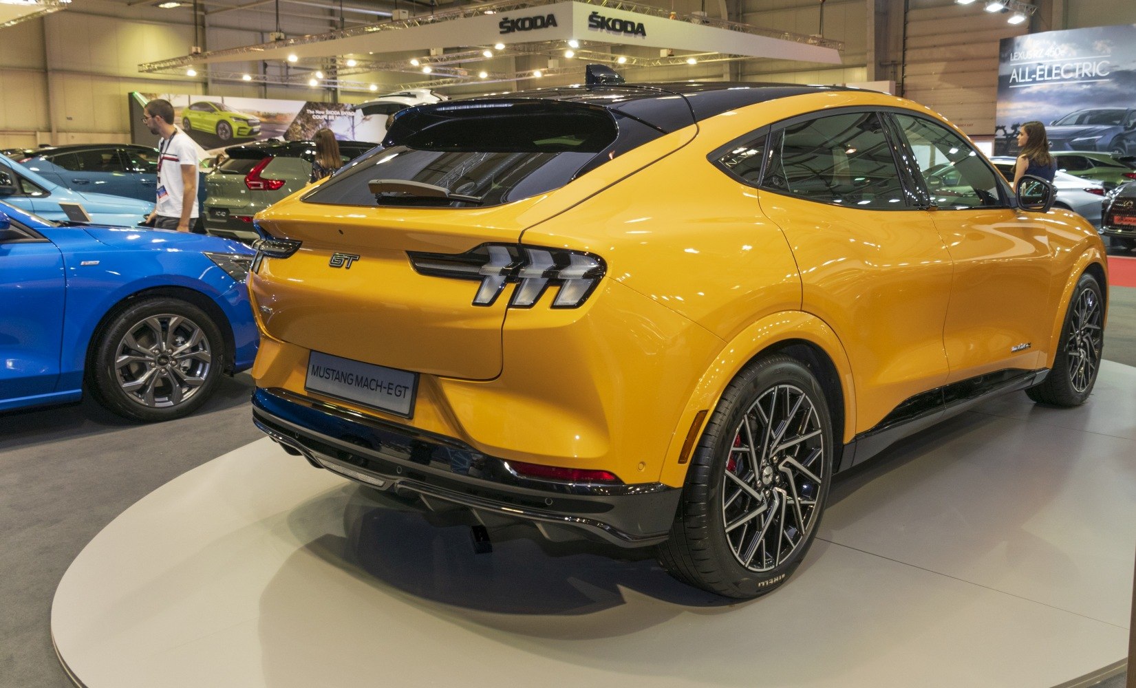 Bright yellow electric SUV rear with unique triple-bar taillights and sporty wheels