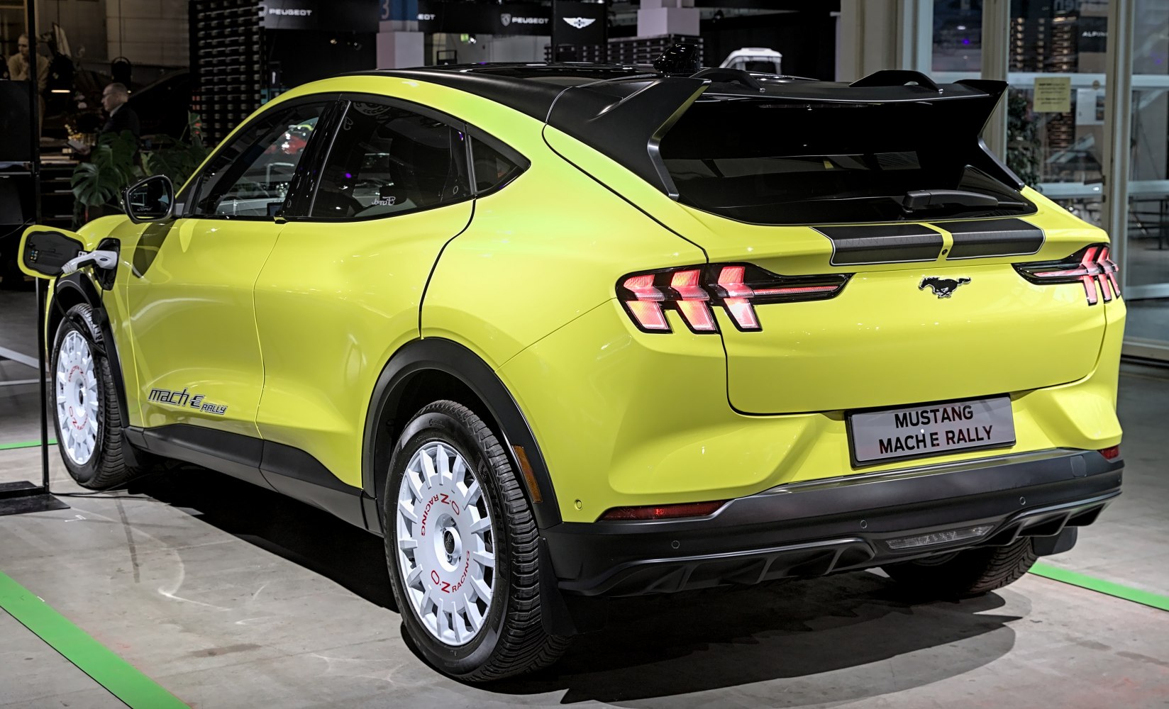 Rear side view of an electric SUV charging with rally wheels
