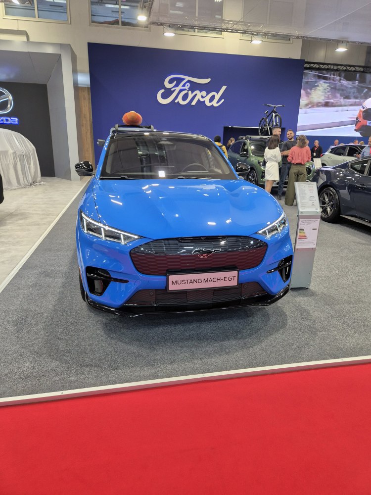 Front view of a sleek blue electric SUV with LED headlights and bold grille