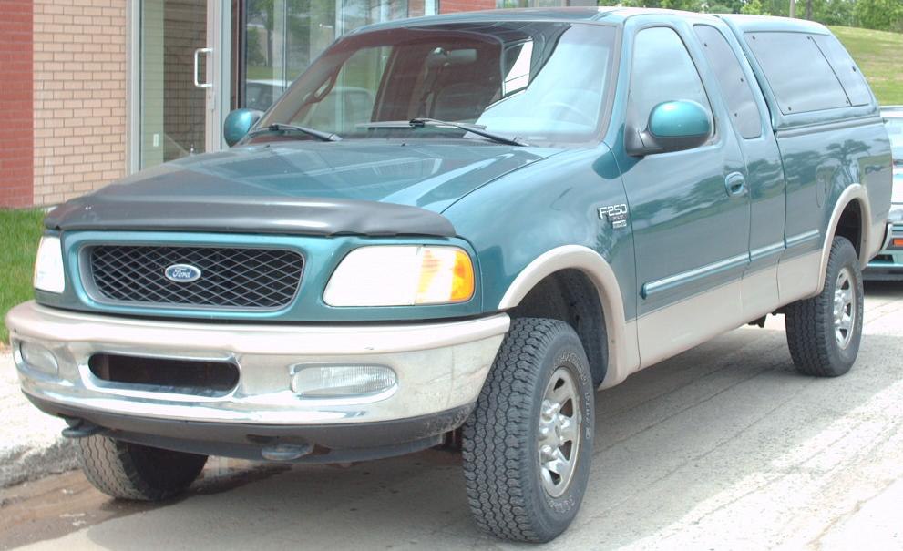 Front side view of pickup truck with grille, headlights, and extended cab