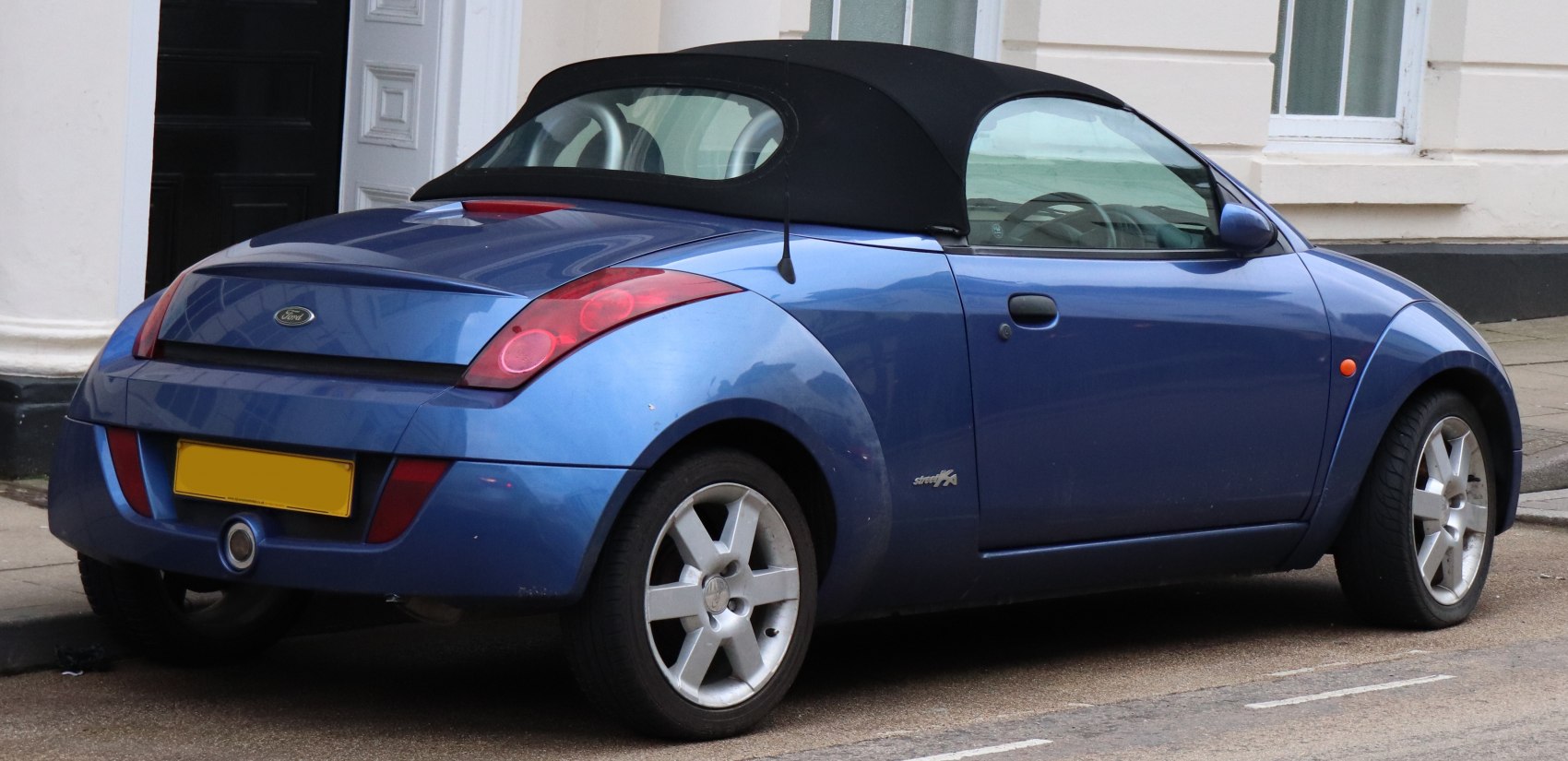 Rear side view of compact convertible with soft top and alloy wheels