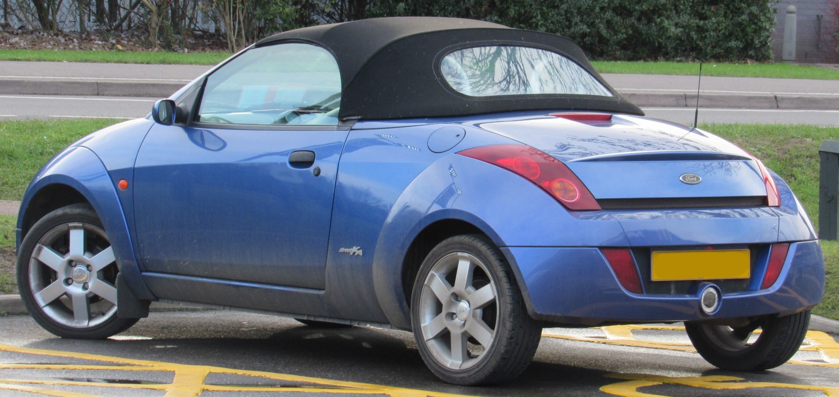 Blue convertible with soft top and rounded rear side profile