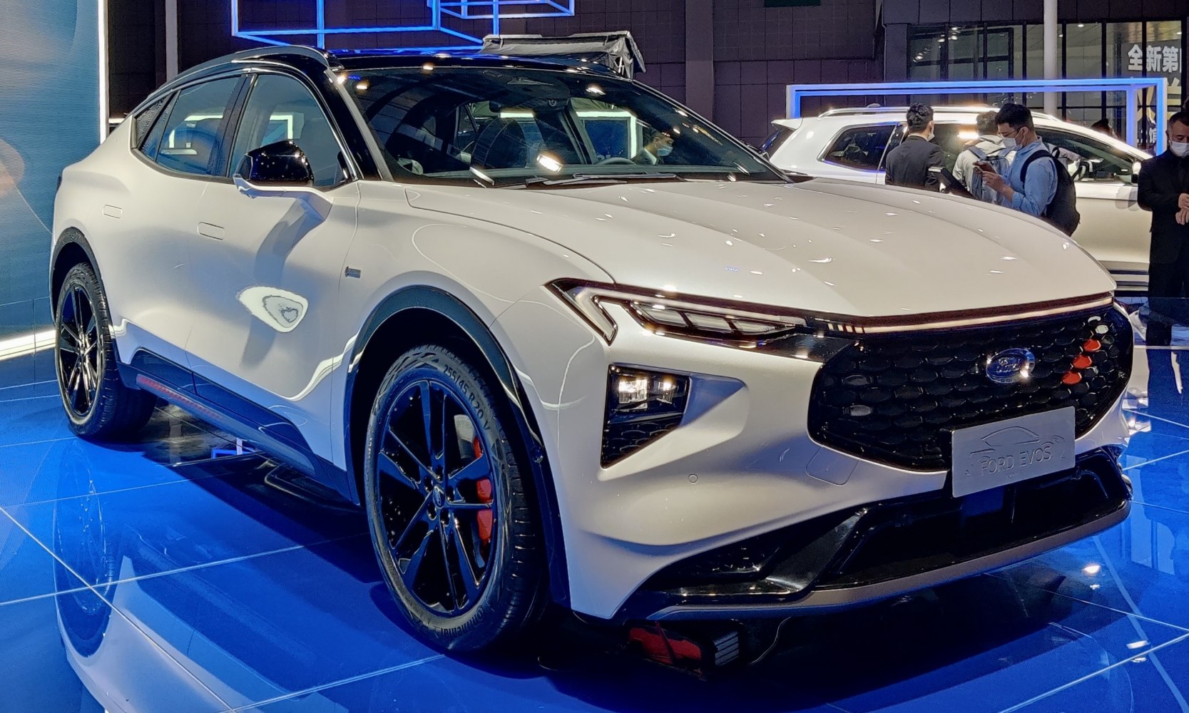 Front-side view of a sleek vehicle with LED headlights and a distinctive grille