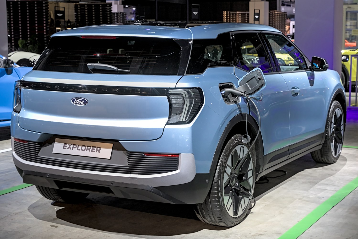 Rear and side view of electric SUV plugged in for charging