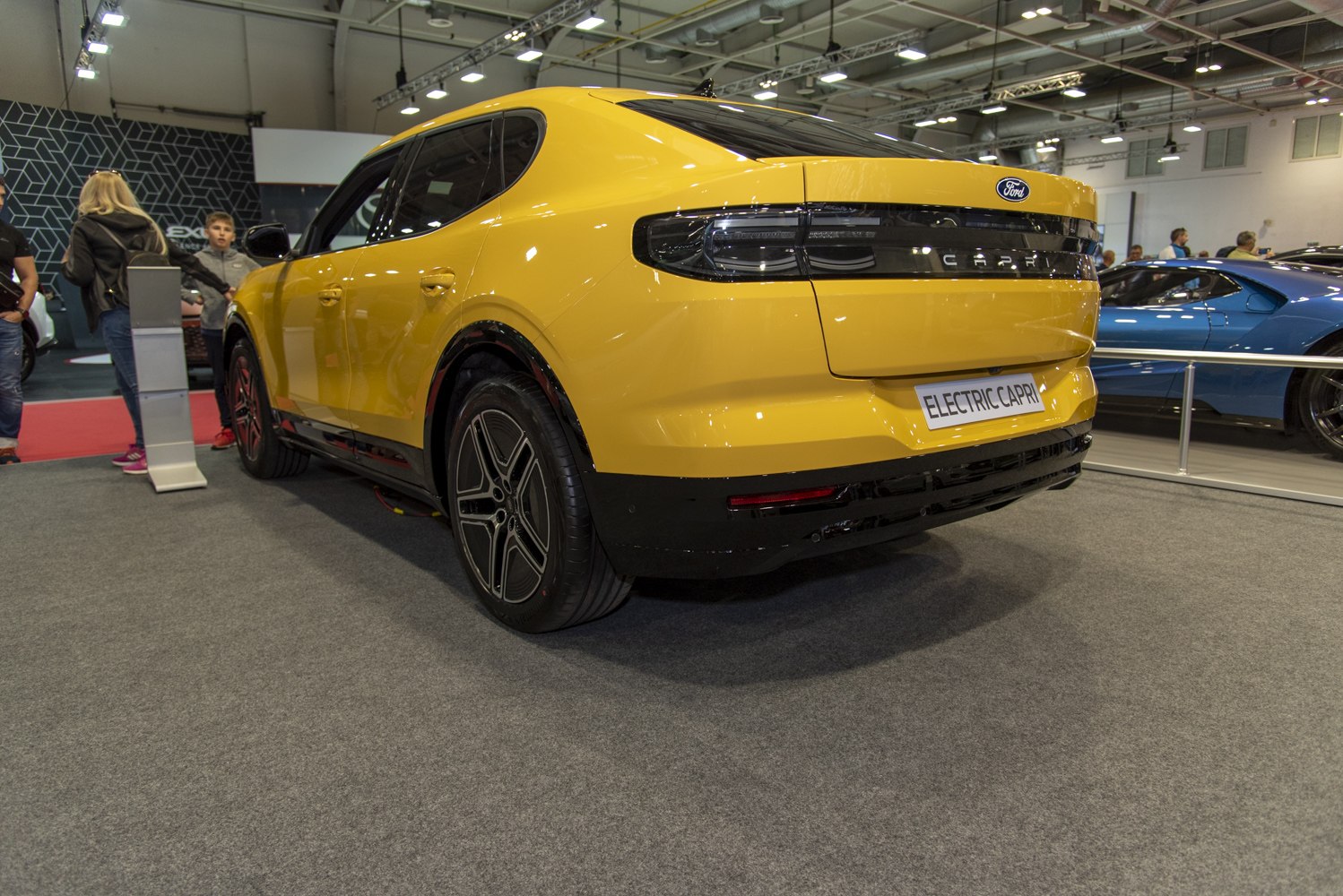 Yellow electric coupe rear with sleek tail lights and aerodynamic design