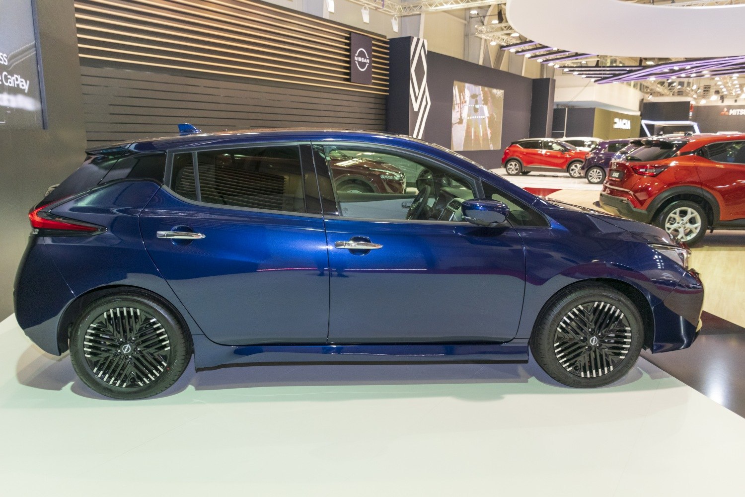 Sleek electric hatchback side profile with distinctive alloy wheels and aerodynamic styling