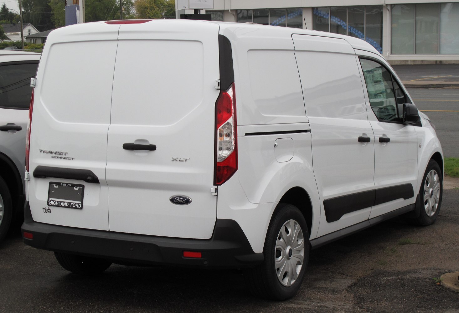 Rear and side view of white panel van with dual rear doors and black trim