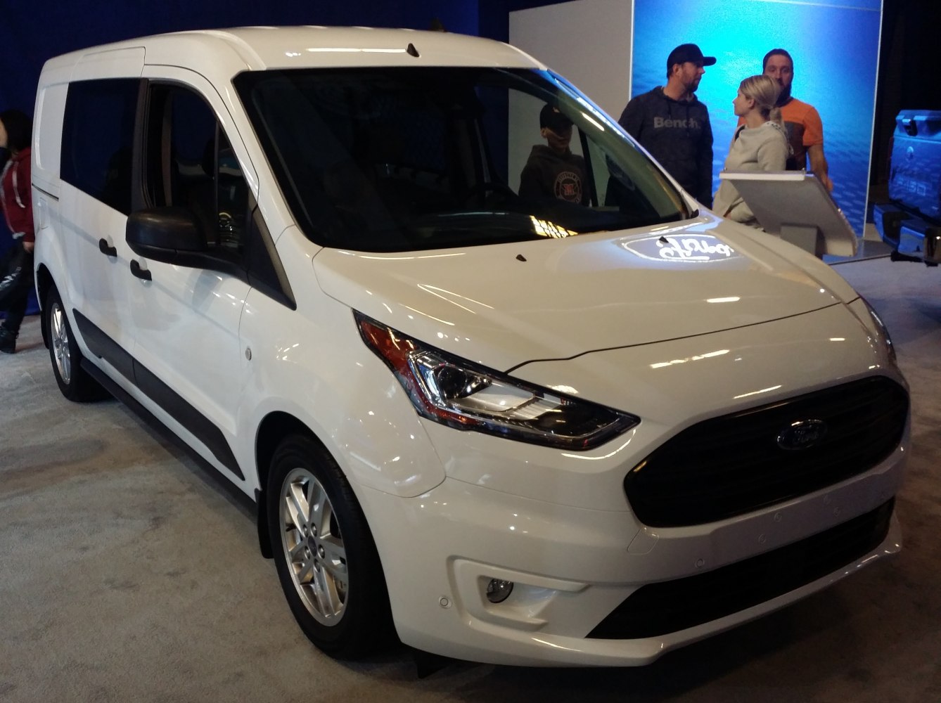 Front-side view of white modern van with extended cab and large passenger cabin