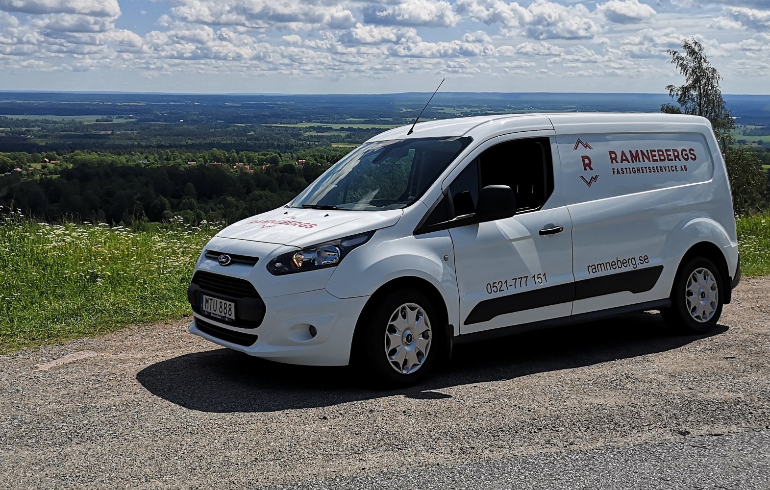 White compact panel van front-side view on countryside gravel road