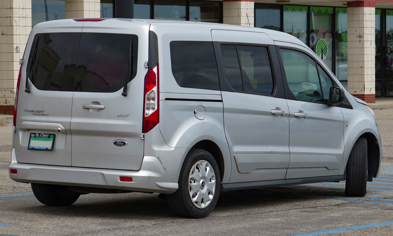 Rear side view of silver van with tinted windows and distinctive rear door