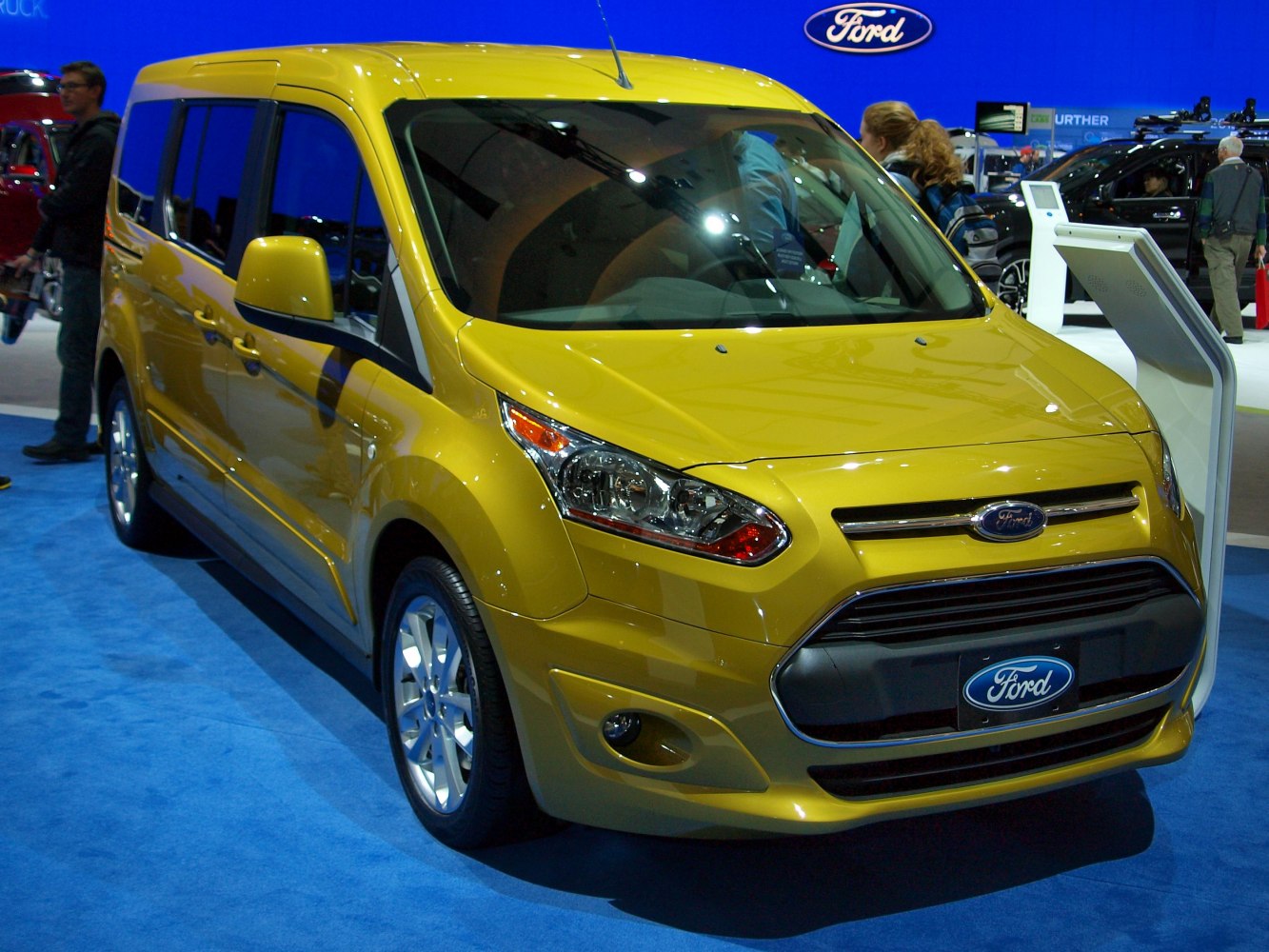 Yellow compact van front exterior with distinctive headlights and grille