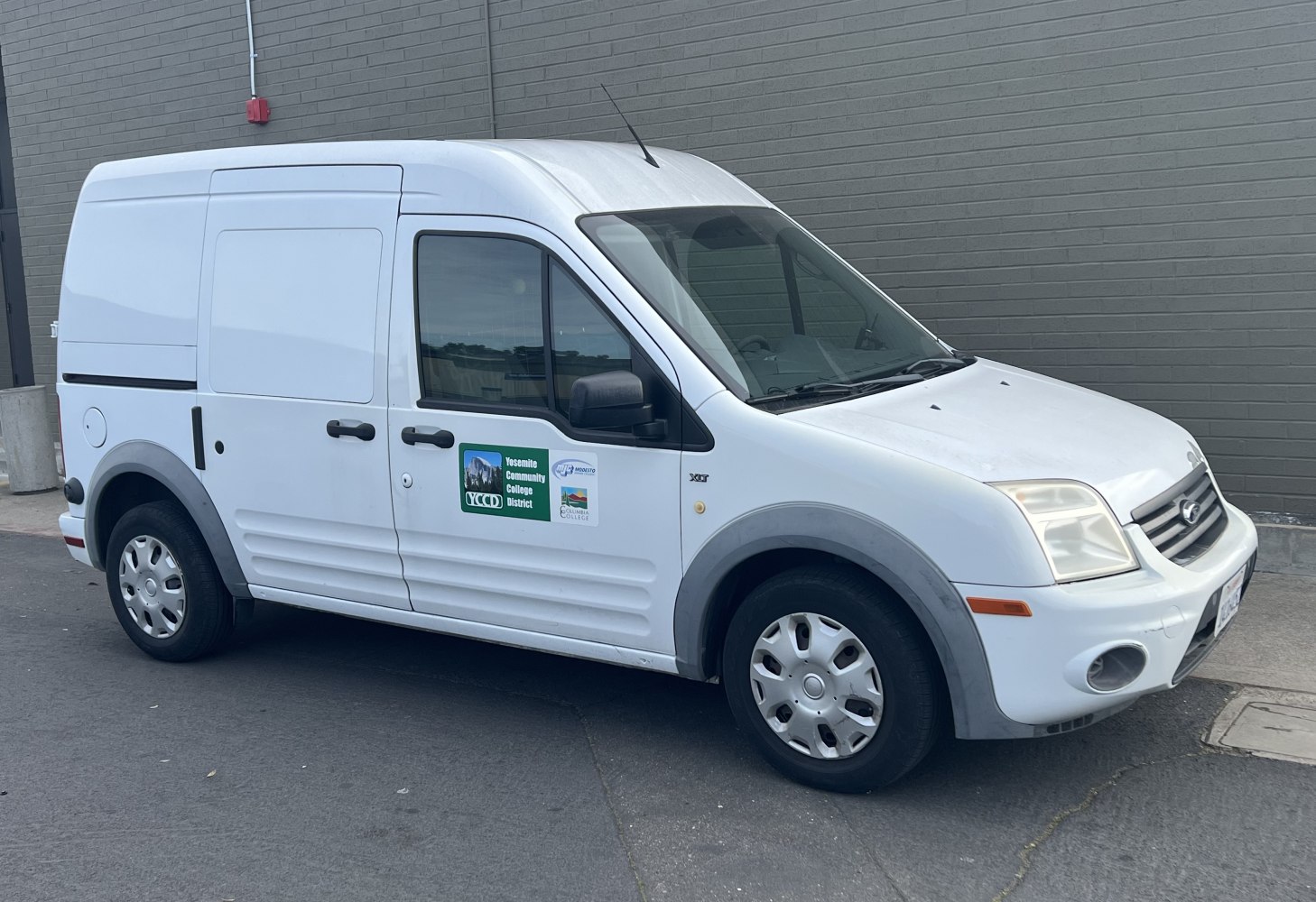 Compact white panel van with sliding side door and hubcaps