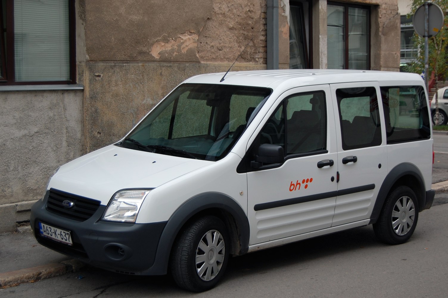 White compact crew van with sliding side door, front side view