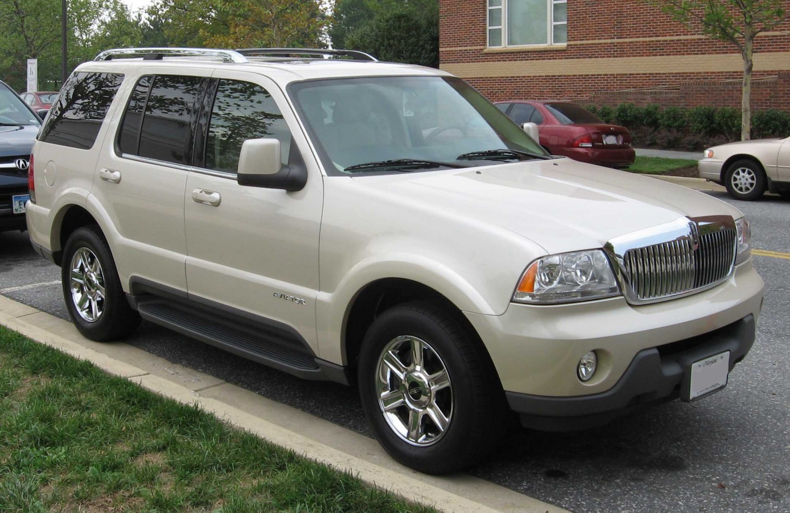 SUV with chrome grille, alloy wheels, roof rails, tinted windows, and running boards