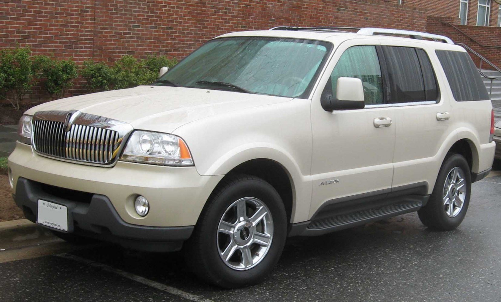 Front three-quarter view of a large SUV with chrome grille and roof rails