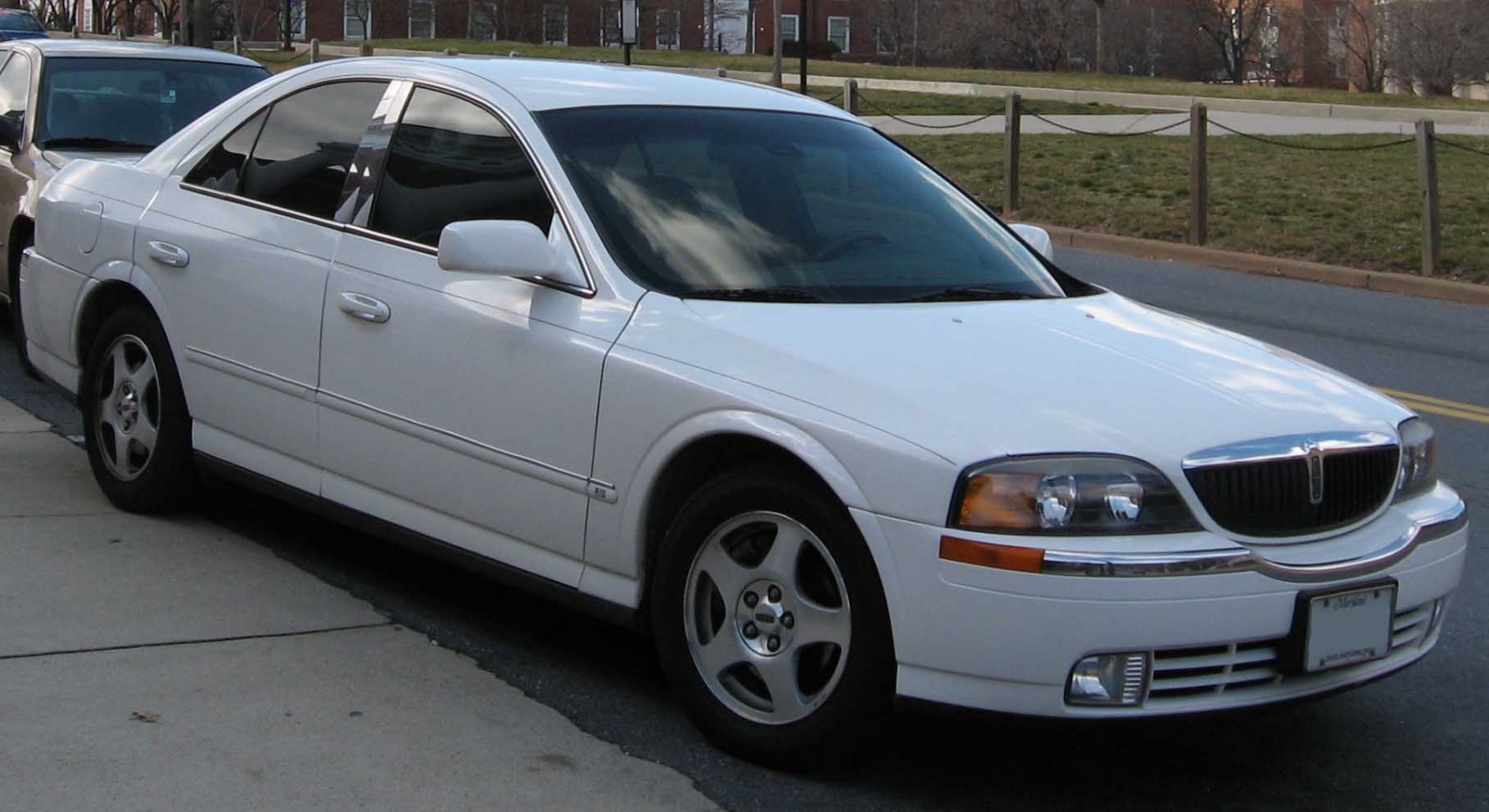 Front side view of a white luxury sedan with alloy wheels and distinct grille