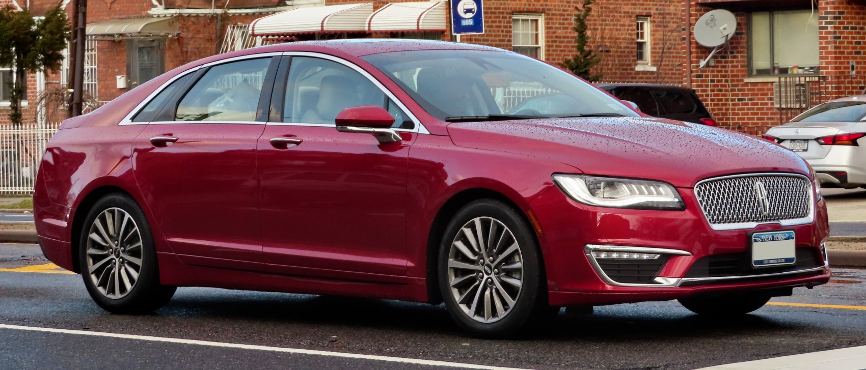 Red luxury sedan with LED headlights and multi-spoke alloy wheels