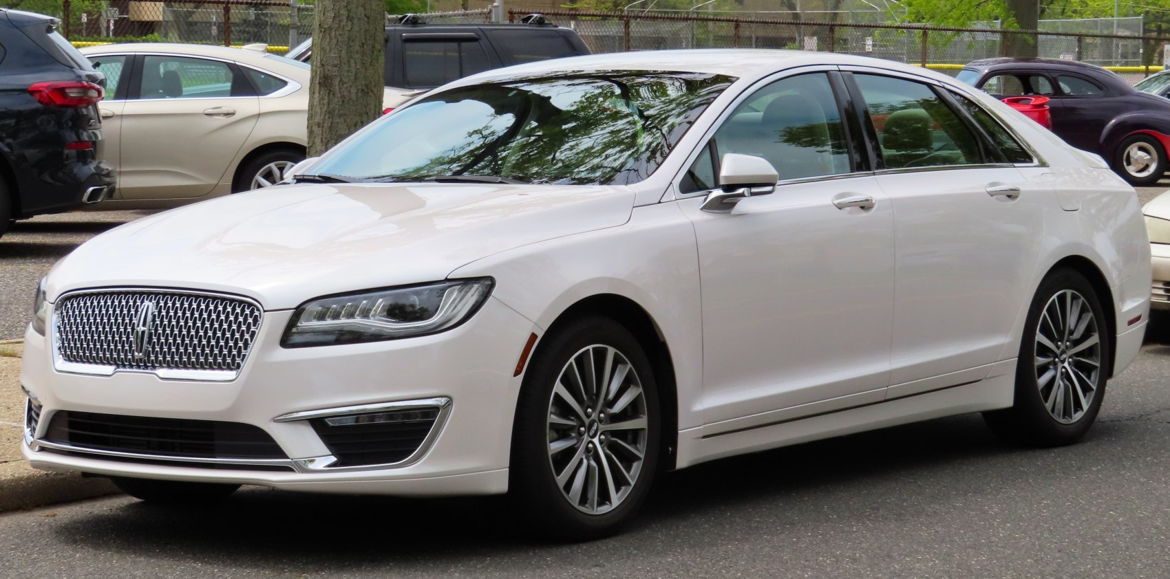 Prominent front grille and multi-barrel LED headlights on sleek sedan profile