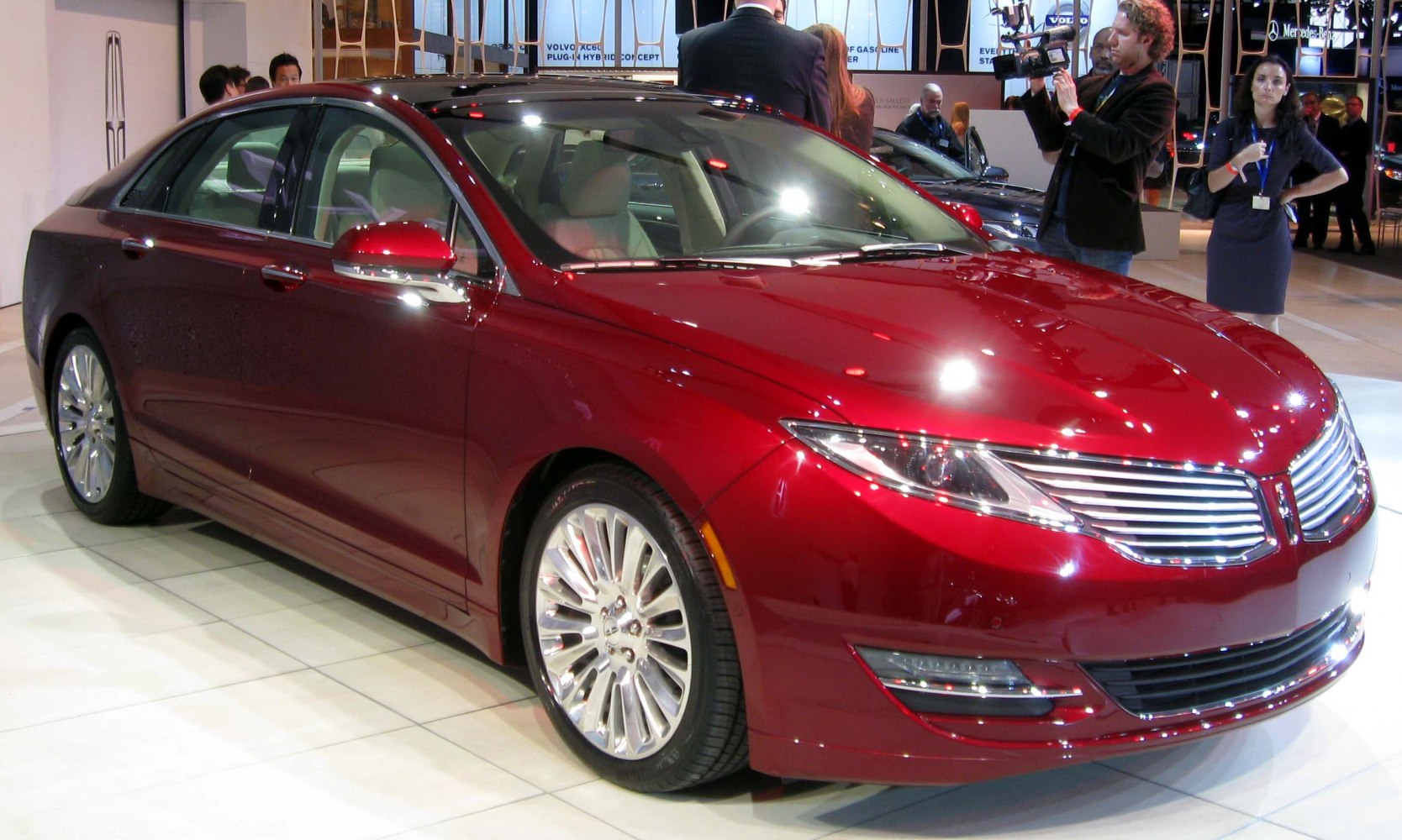 Red luxury sedan with chrome grille and multi-spoke wheels