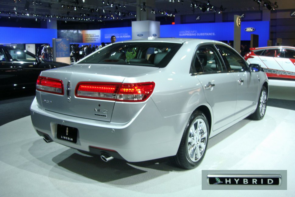 Rear view of a hybrid sedan with illuminated taillights and dual exhaust