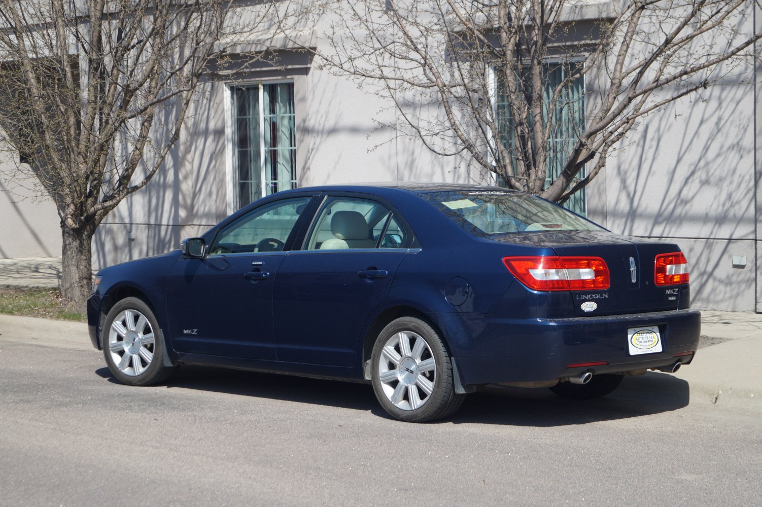 Blue midsize sedan rear and side profile with taillights and alloy wheels