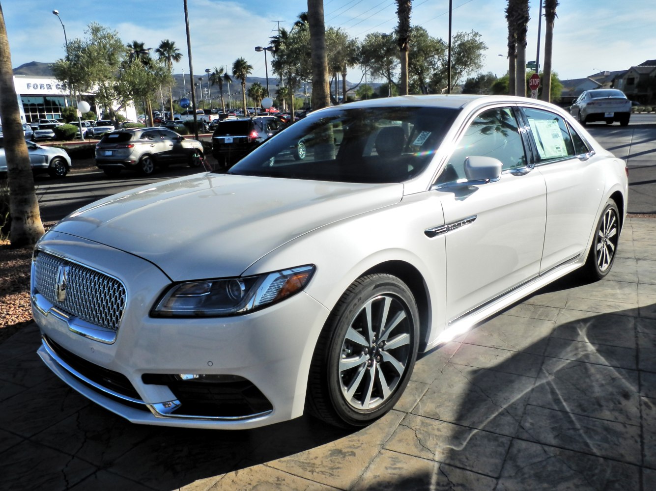 White luxury sedan with bold grille and sleek headlights