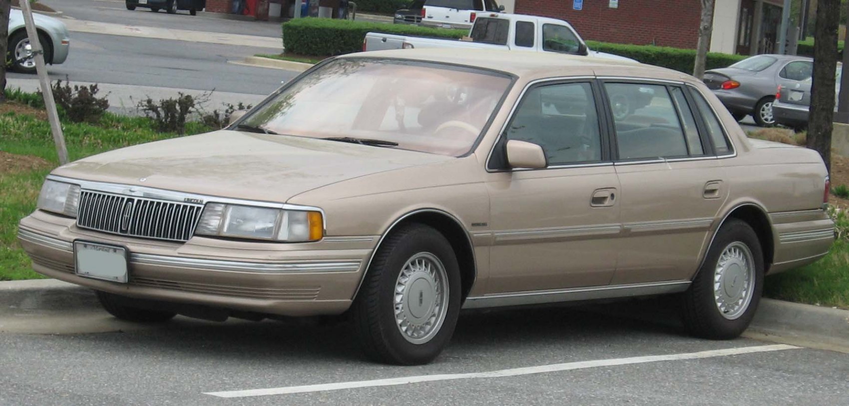 Full-size beige sedan with vertical grille and alloy wheels