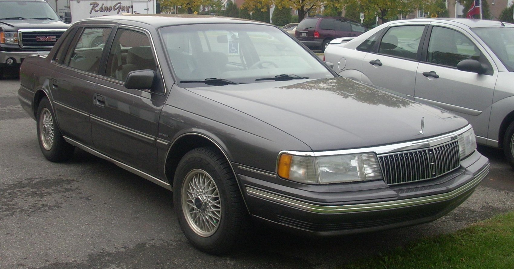 Wire-spoke wheels and vertical slat front grille on classic sedan