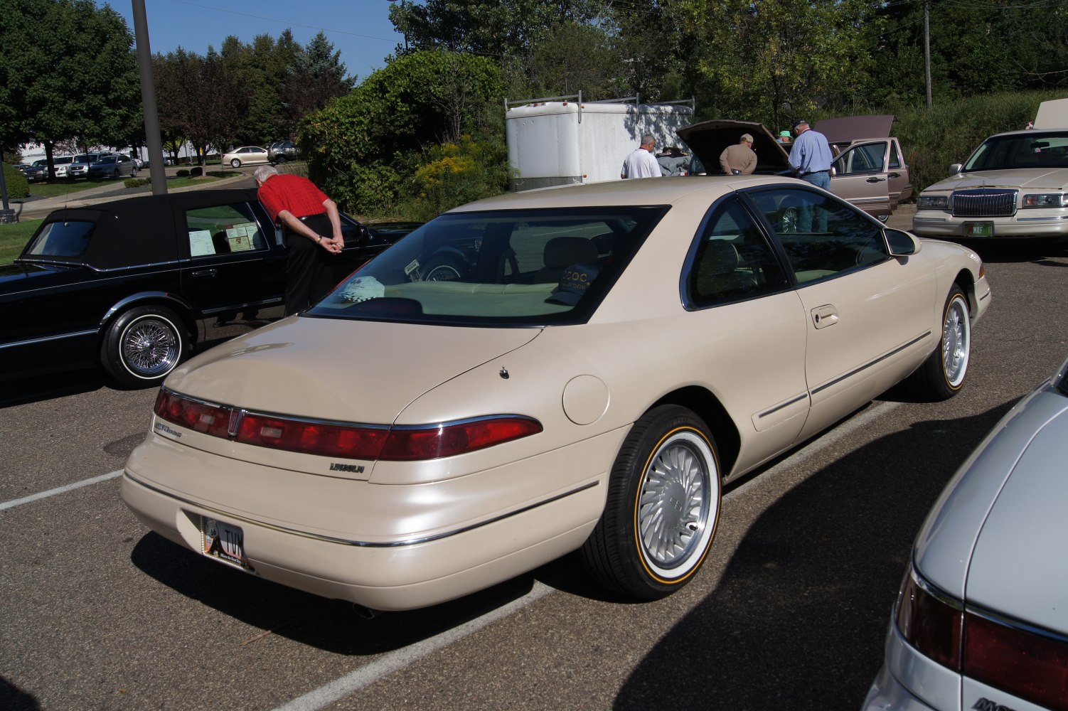 Rear view of vintage luxury coupe with distinct tail lights and classic hubcaps.