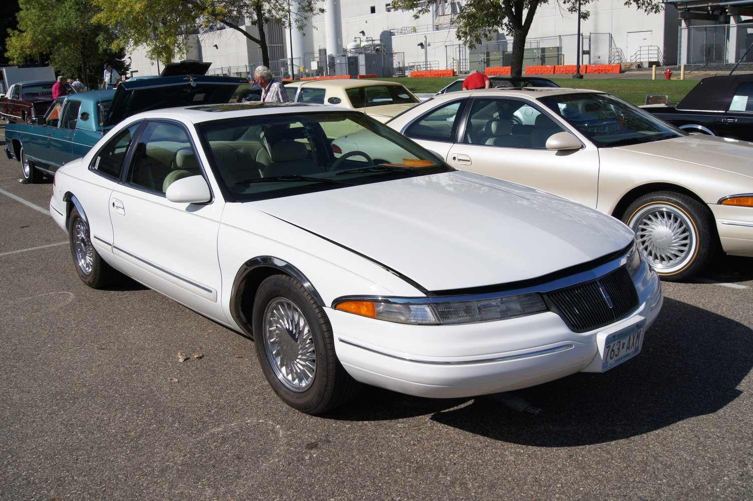 White retro coupe with chrome spoked wheels and distinctive grille.