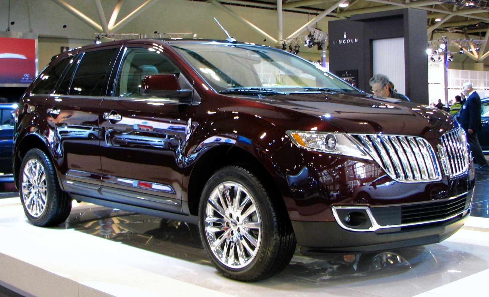 Facelift SUV with vertical slat grille and multi-spoke chrome wheels