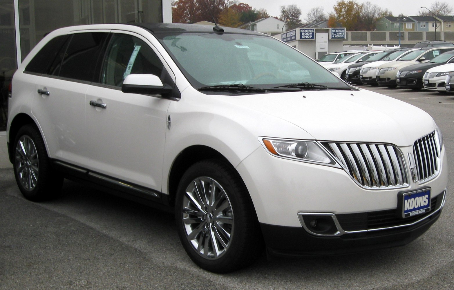 Vertical chrome grille and alloy wheels on SUV front-side view