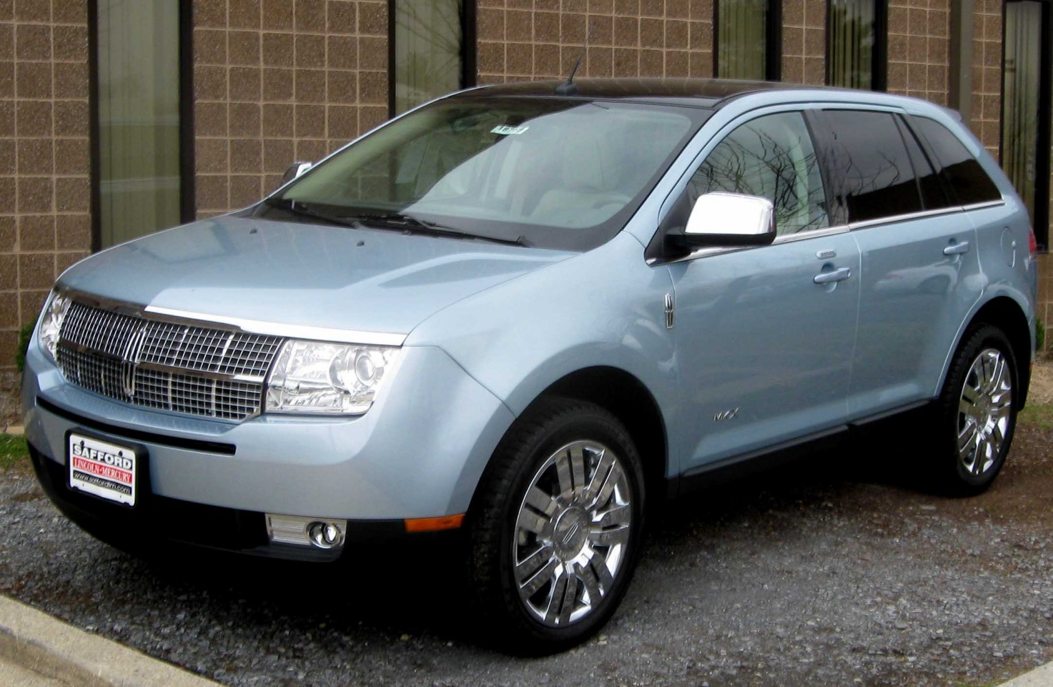 Front-side view of luxury SUV with chrome grille and wheels