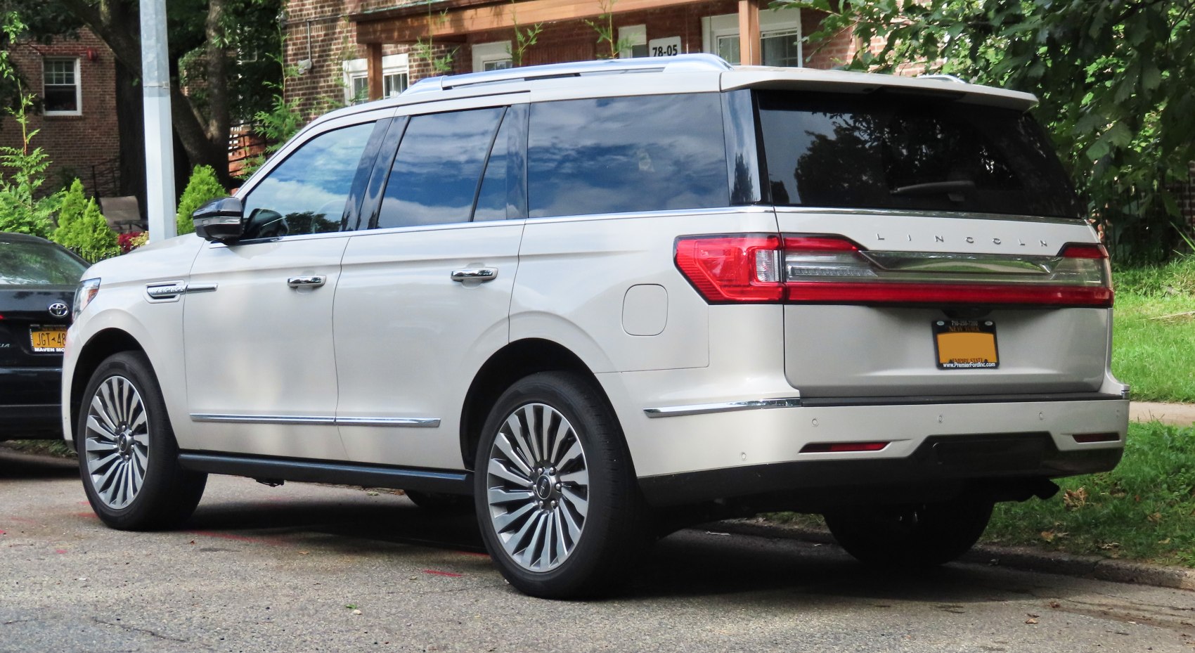 Rear side view of a large luxury SUV with detailed taillights and alloy wheels.