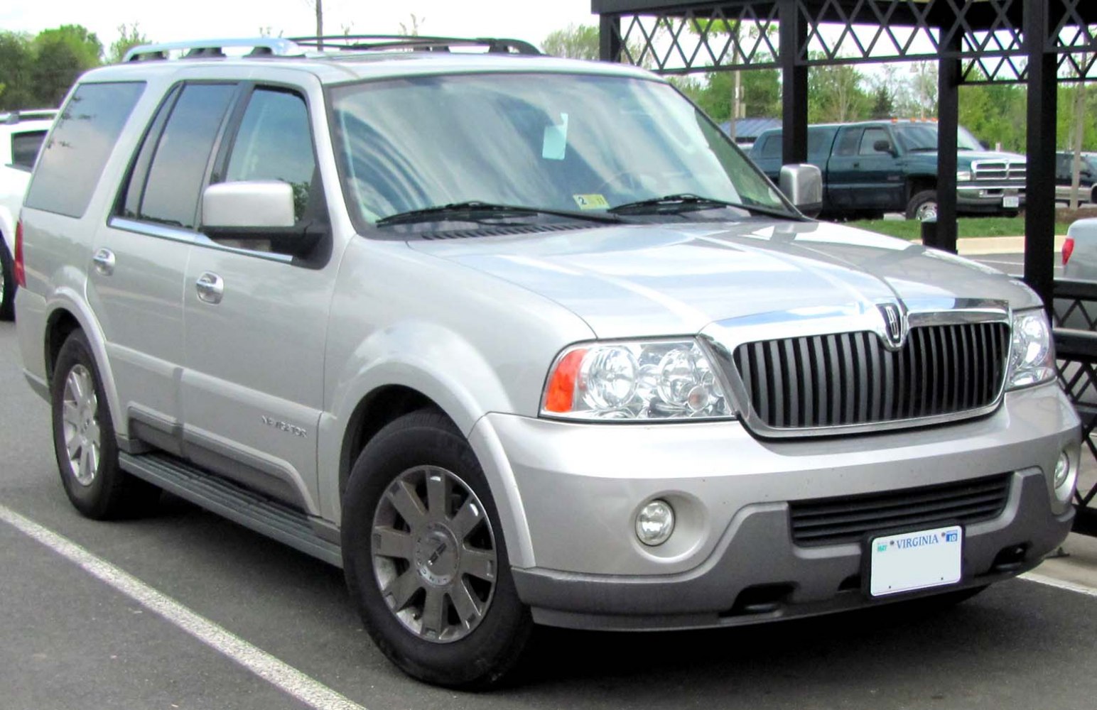 Silver large SUV with vertical grille and round fog lights