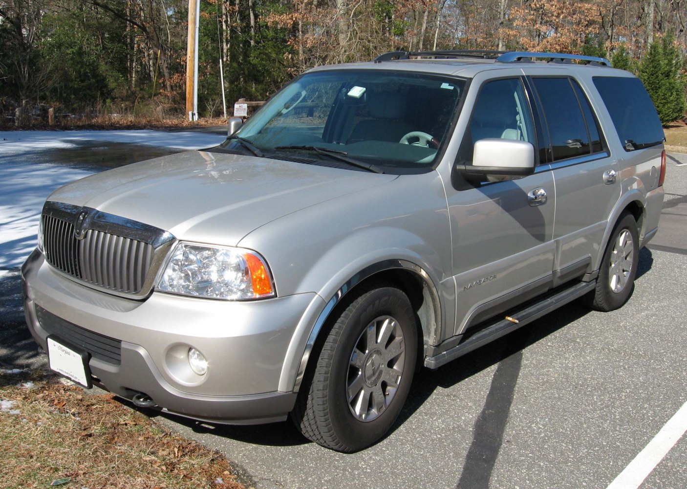 Silver metallic full-size SUV with front grille and alloy wheels