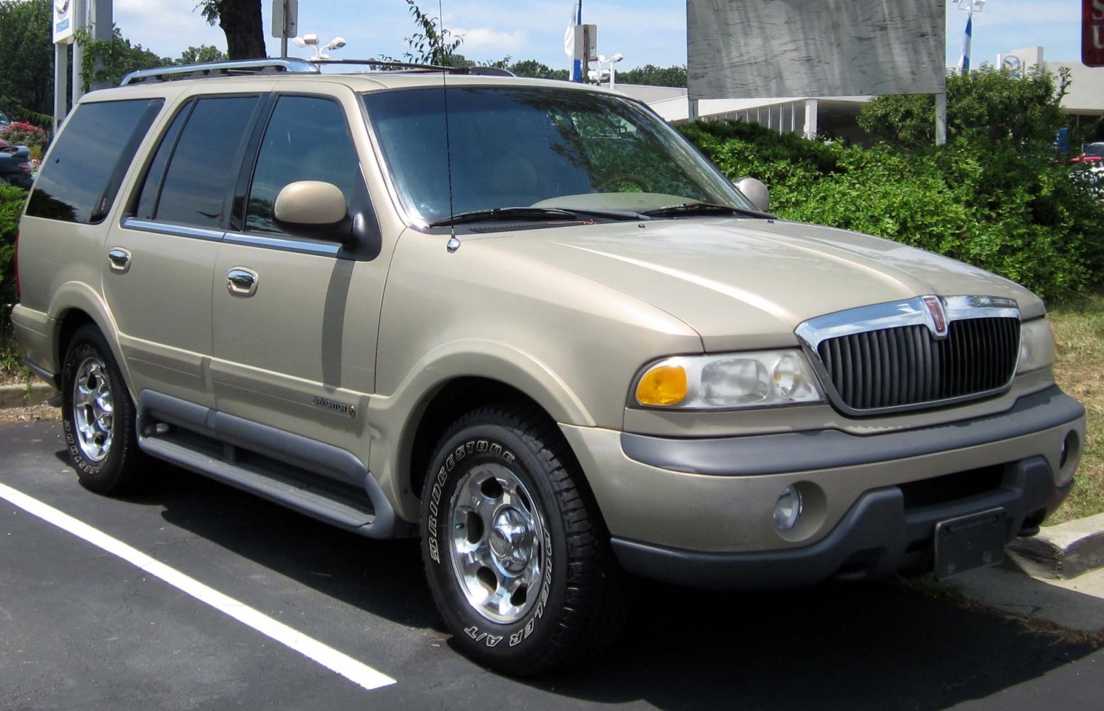 Front side view of full-size SUV with chrome wheels and roof rails