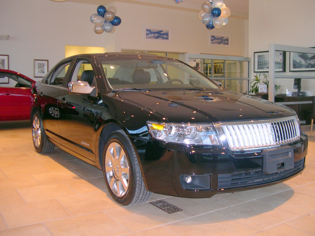 Chrome front grille and clear headlight assembly on a black sedan