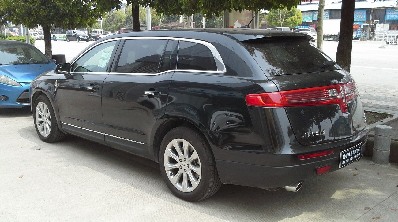 Rear side view of black SUV with signature taillights and chrome trim