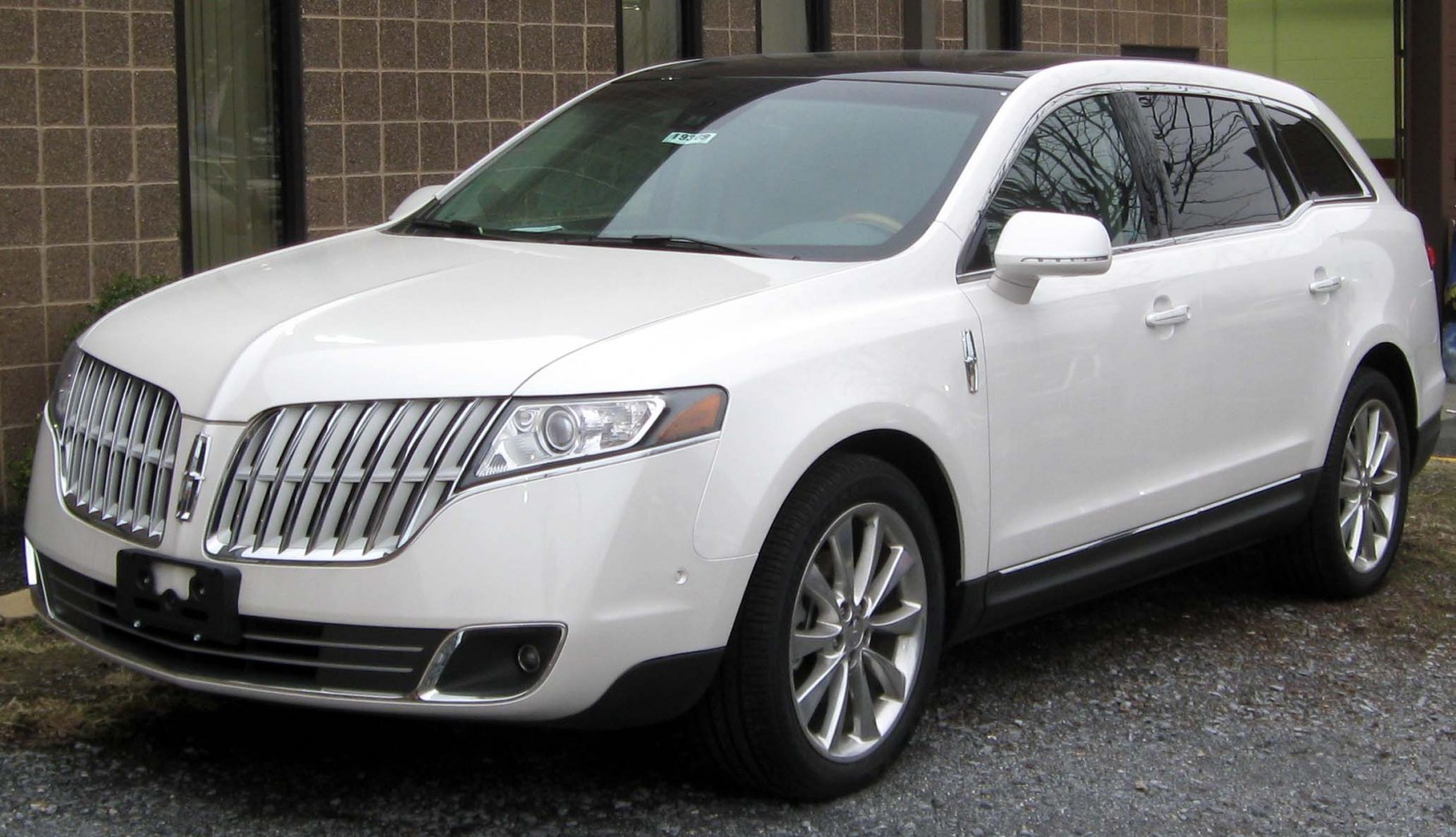 White luxury SUV front side with distinctive grille and alloy wheels