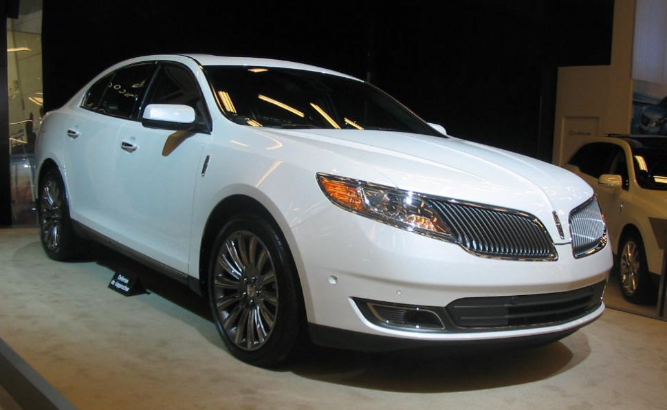 White sedan with prominent chrome grille and multi-spoke alloy wheels